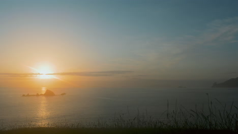 a sunrise or sunset over a new zealand hill, with vibrant orange and blue tones