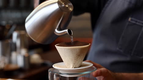 close-up of a barista preparing pour-over coffee