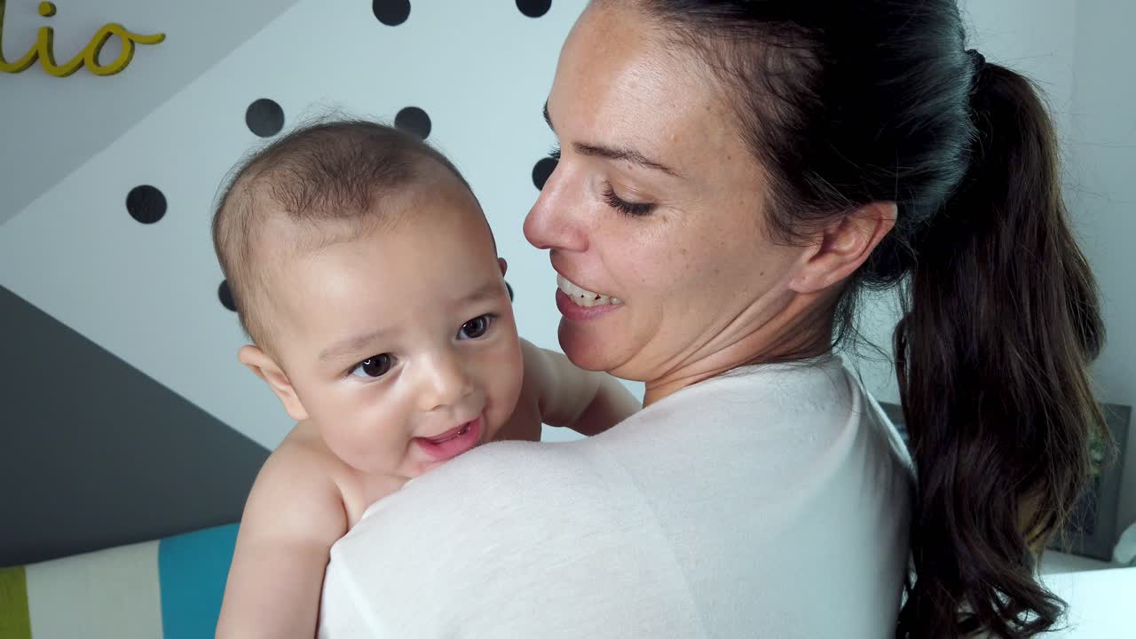 Mamma gioiosa con il bambino in camera da letto