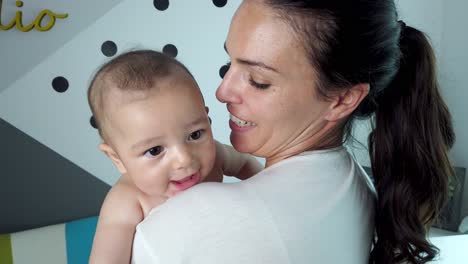 madre alegre con el bebé en el dormitorio