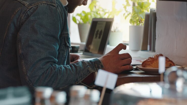 giovane che legge un documento aziendale in un caffè che lavora a un progetto che beve caffè che fa brainstorming di idee