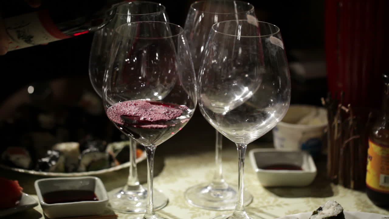 Vino rosso viene versato nei bicchieri