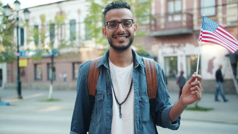 man holding american flag in city
