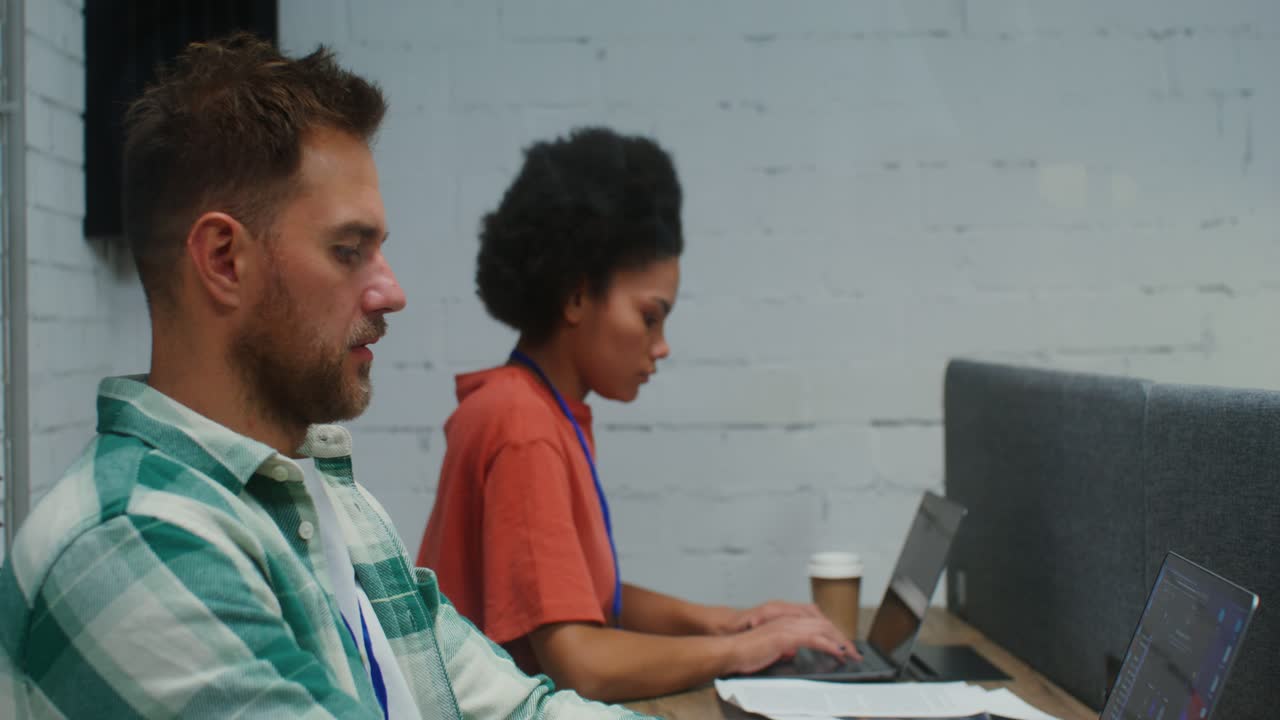 Two people working at a desk in an office setting