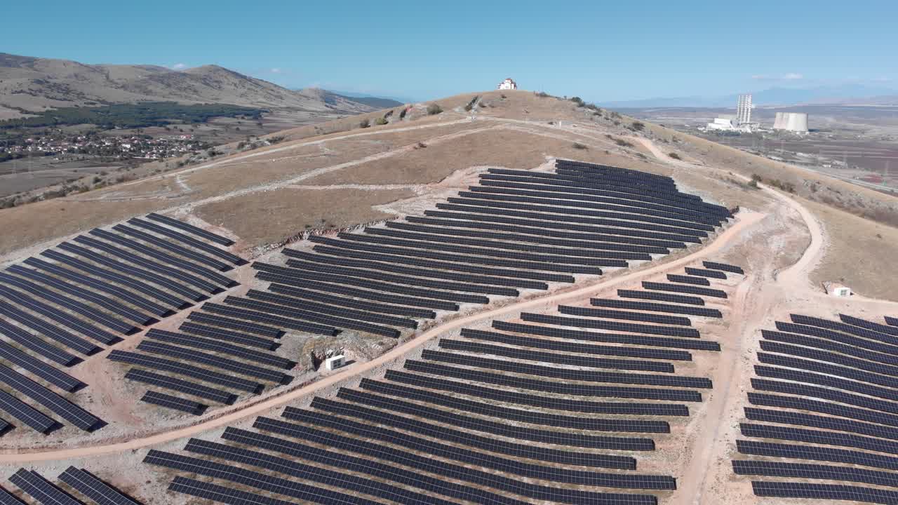 colina de drones en órbita con parque de energía solar fotovoltaica paneles de fila de granja vieja central eléctrica de carbón de fondo