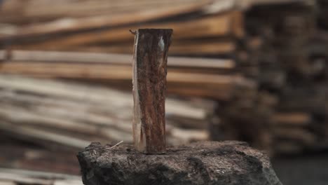 Close-up of man's hands chopping wood with an ax on a blurred wooden background