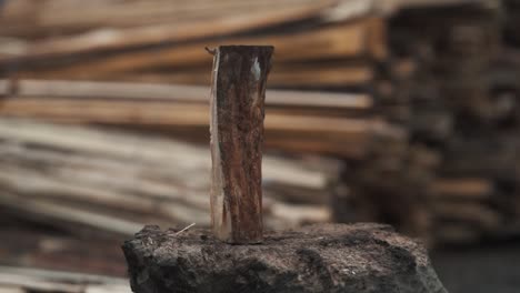 close-up of man's hands chopping wood with an ax on a blurred wooden background