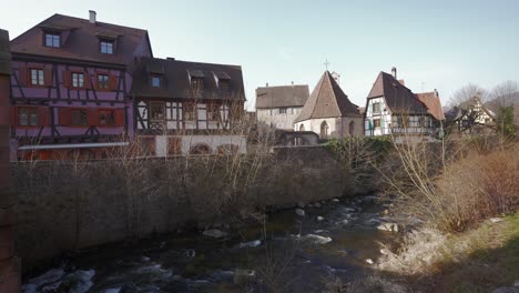 touristische mittelalterliche stadt, holzarchitekturhäuser und fließender fluss in kaysersberg, frankreich