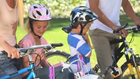 pareja de jóvenes en bicicleta con sus dos hijos pequeños