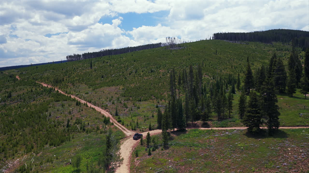 Mount of the Holy Cross Notch Mountain creek Falls Creek Trail Half moon pass AWD car driving dirt road car aerial drone Rocky Mountains Colorado Vail Minturn Red Cliff summer morning blue sky clouds