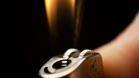 Slow-motion flick: Delight in the enchanting display of sparks and flames as a hand flicks a lighter in mesmerizing slow motion
