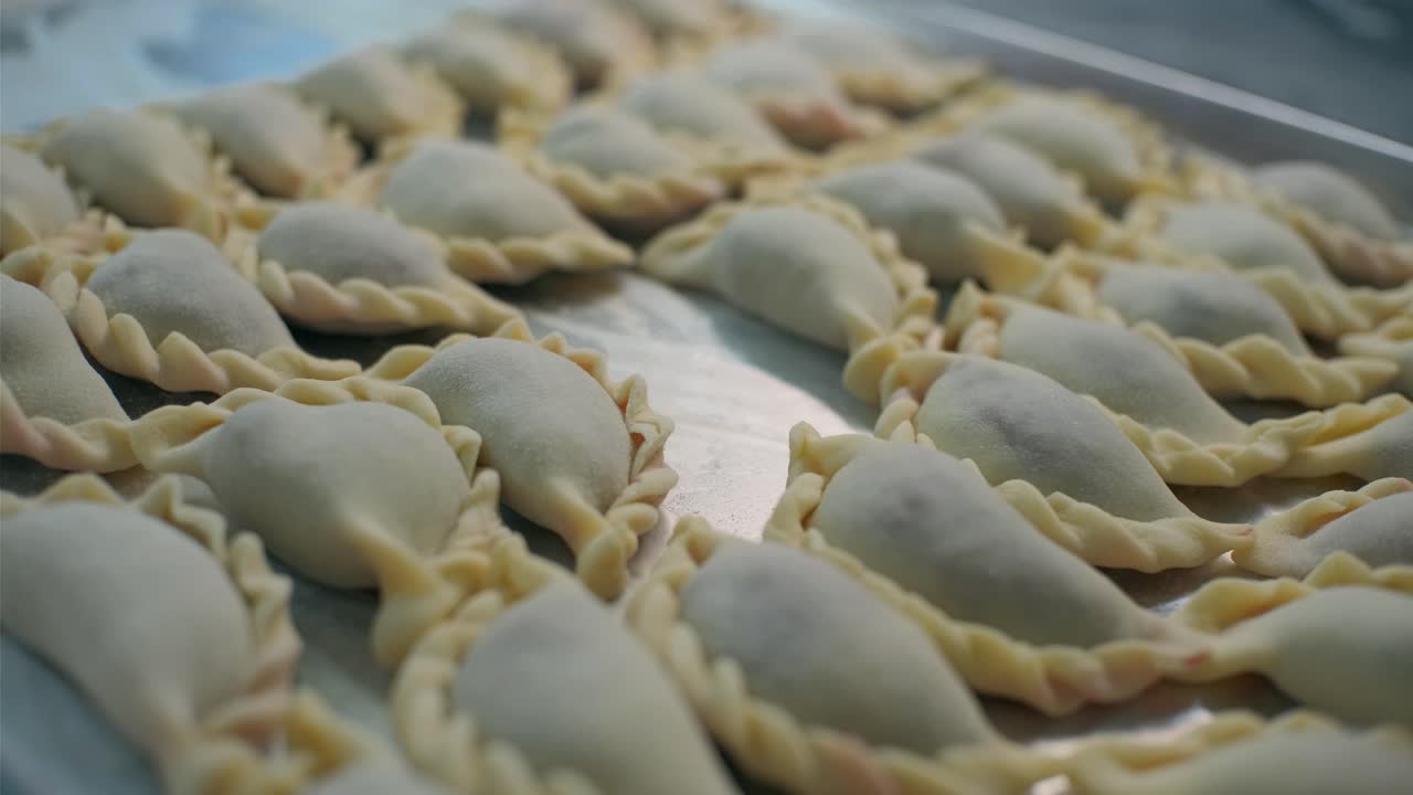 Pierogi crudi su una teglia da forno