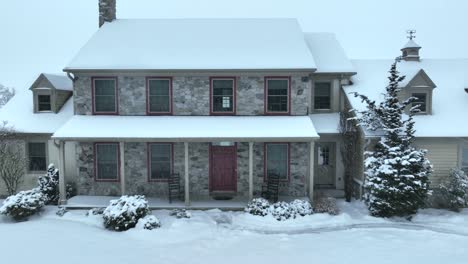 aerial shot of a farmhouse on a snowy winter day