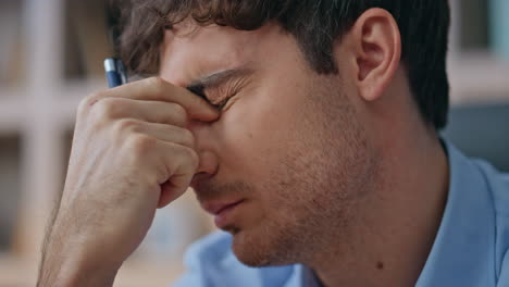 businessman suffering eye strain overwork in office closeup. tired man thinking