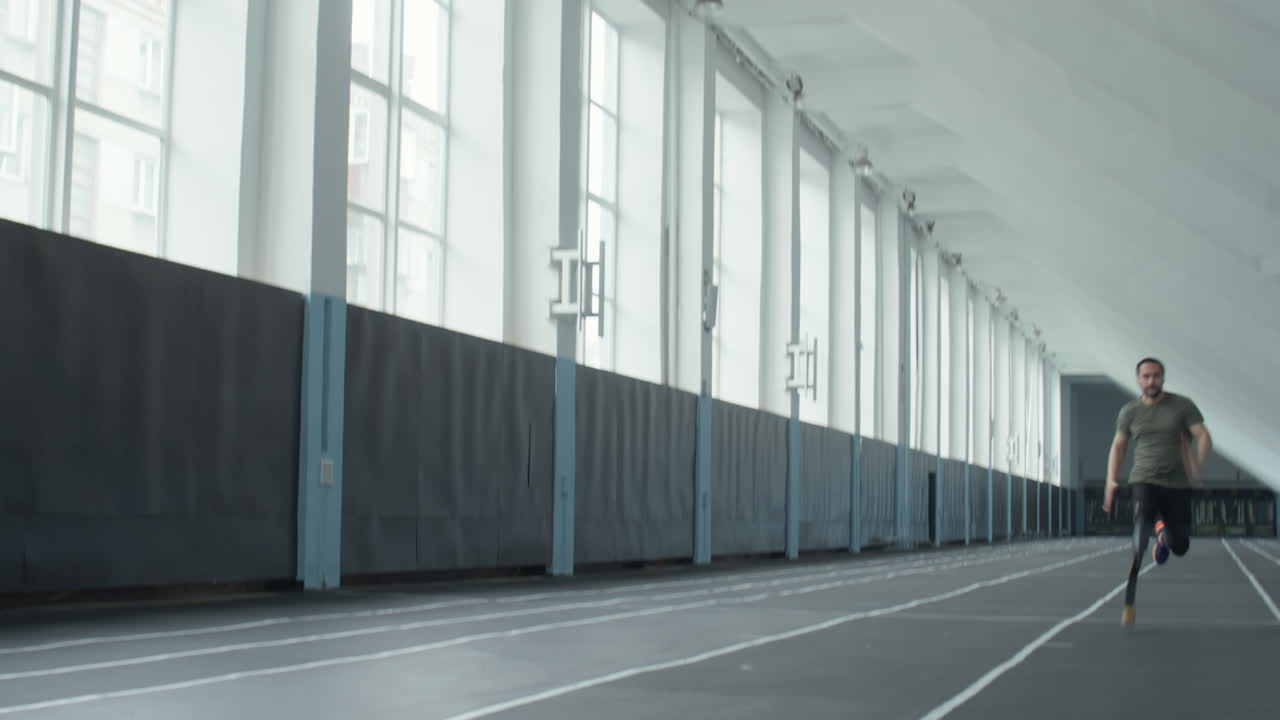 Male Athlete with Prosthetic Leg Running in Stadium
