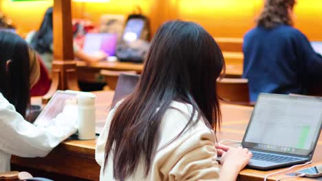 people working on laptops in library setting