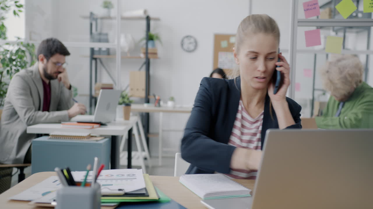 Kvinne i telefonsamtale på kontor