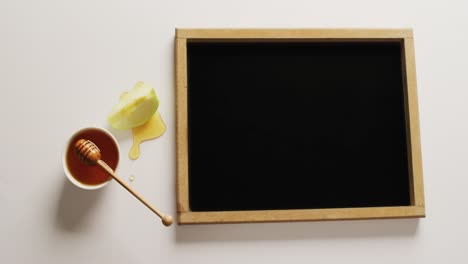 video oc black board with copy space, honey in jar and apple slice on beige background