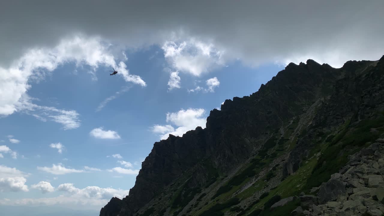 helicóptero de rescate de montaña sobrevolando la cumbre del alto tatra en un día soleado y nublado
