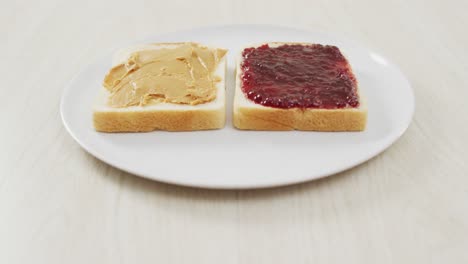 Close-up-view-of-peanut-butter-and-jelly-sandwich-on-wooden-surface