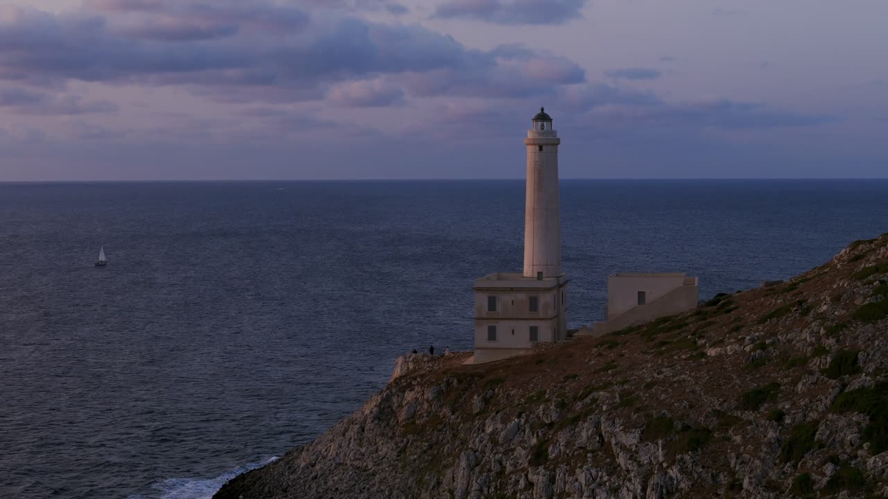 otranto, puglia, italia - una vista panorámica del faro palascia enclavado en el promontorio, frente al mar adriático al atardecer - panorámica hacia abajo