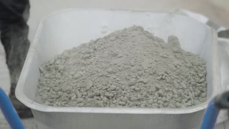 two people Shovelling ready mix concrete into a near full wheelbarrow