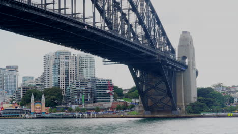 A-ferry-passes-underneath-Sydney-harbour-bridge-in-Australia
