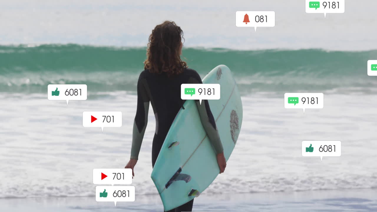 Woman surfer standing on beach with blue surfboard, showing floating social media marketing icons