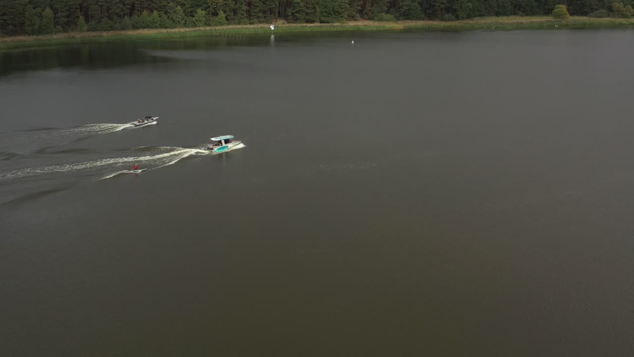 drone skud af surferpige på longboard bag båd