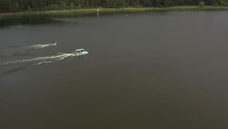 drone-shot-of-surfergirl-on-longboard-behind-boat