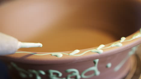 Close-Up-Of-Male-Potter-Pattern-Onto-Bread-Bowl-In-Ceramics-Studio