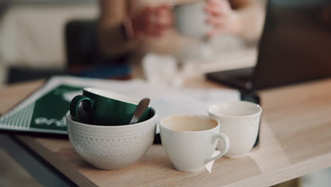 woman working from home with coffee cups and a laptop