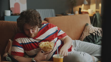 man eating chips on couch