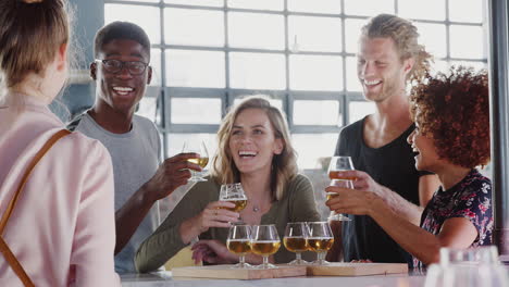 waitress serving group of friends at beer tasting in bar