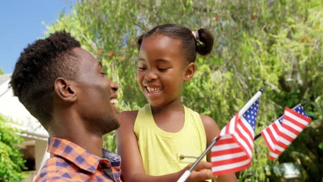 Man-holding-his-daughter-and-American-flag