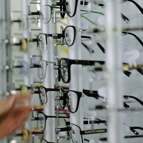 una chica eligiendo gafas.
