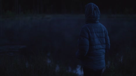 person watching a fog rolling over the lake at night, dark moody atmosphere