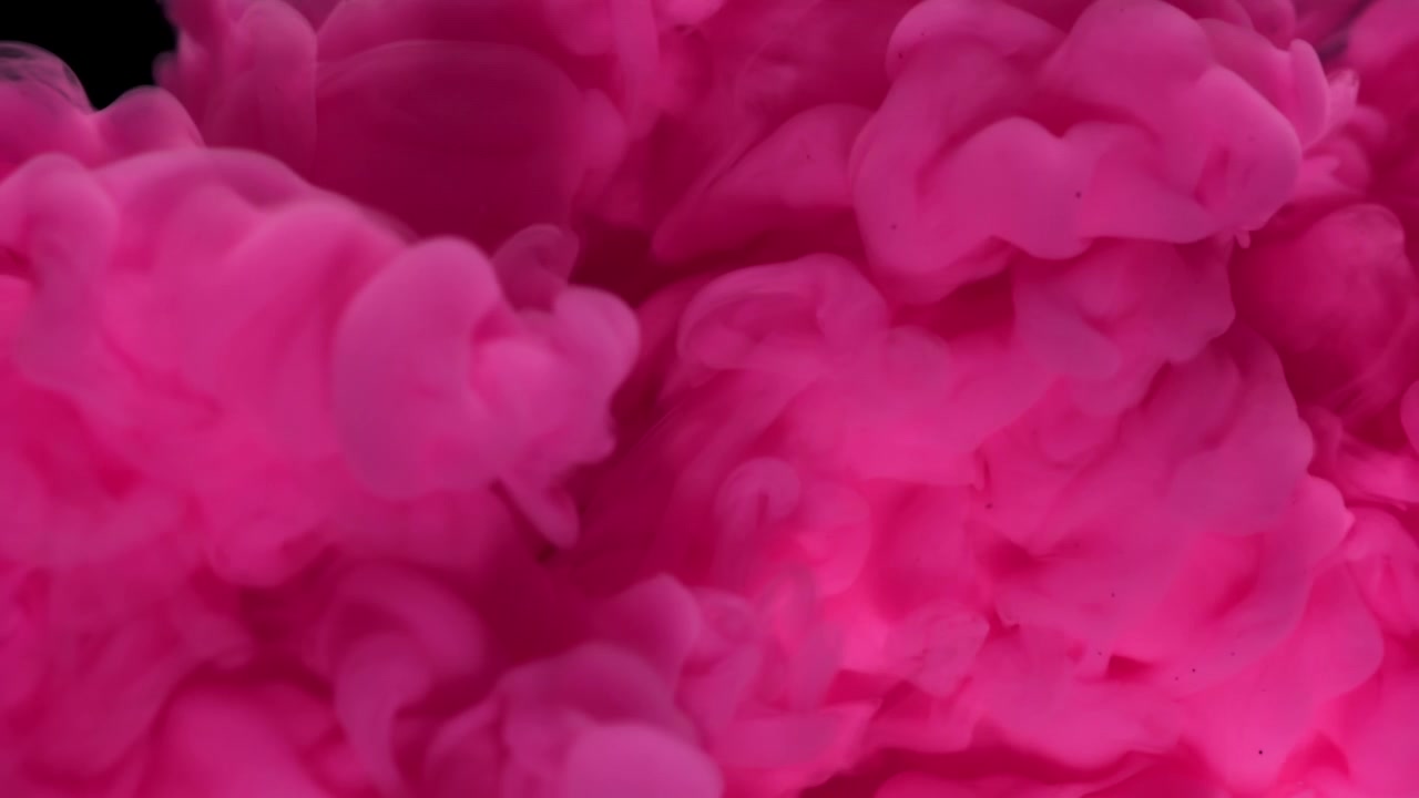 Tinta rosa vibrante dispersándose en agua sobre fondo negro