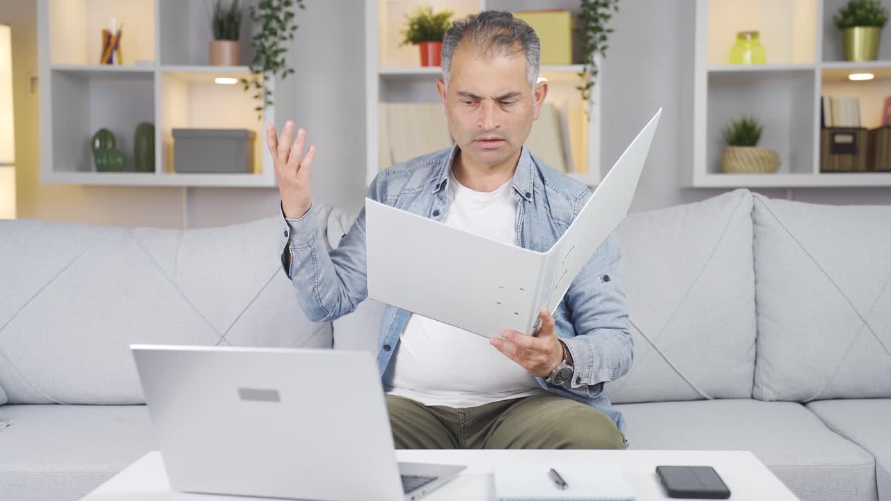 el hombre que trabaja en la computadora portátil lanza archivos enojado.