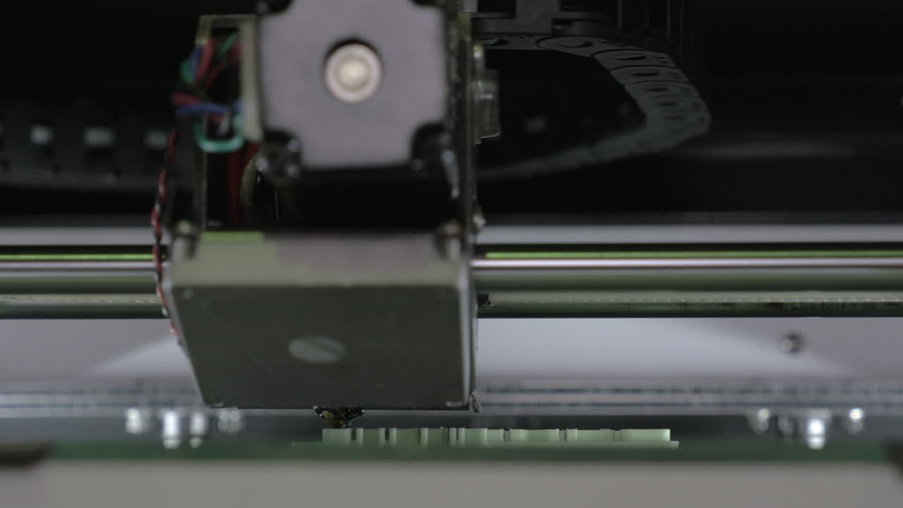 Extreme close-up view of mechanism of 3d printer making white plastic object