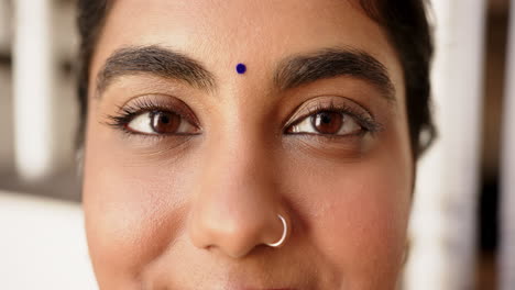 close-up of indian woman with nose ring and bindi smiling confidently