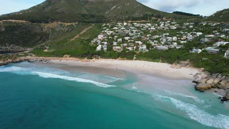 turquoise-blue-ocean-at-Llandudno-Beach-with-waterfront-hotels-on-the-hillside,-aerial