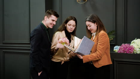 mujer asiática mostrando un libro de muestra a una pareja