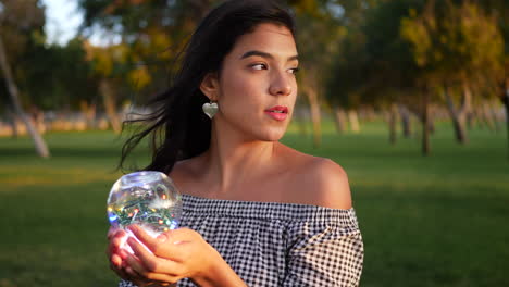 a beautiful sorceress holding a magic glowing crystal ball with an enchanting and mysterious look