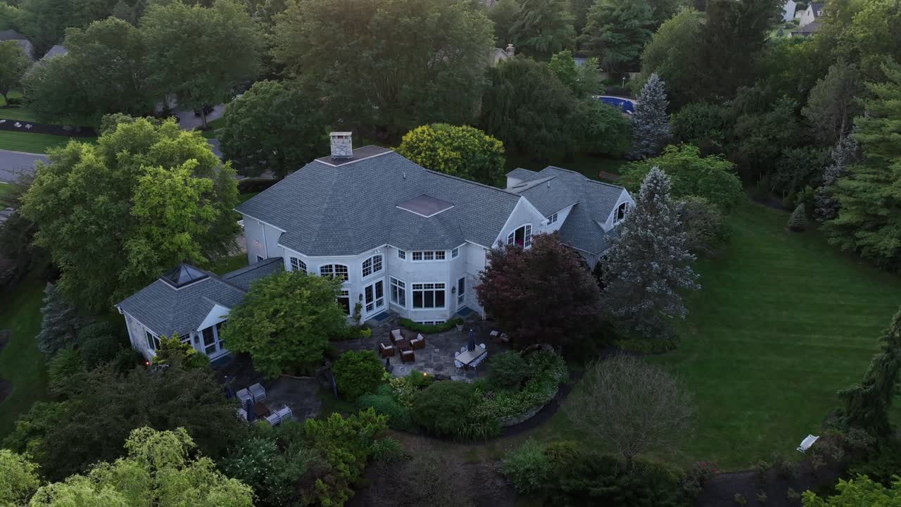 Luxury Victorian villa building in green suburb neighborhood of town. Aerial top down. Large property and real estate in American style. Sunset time in summer
