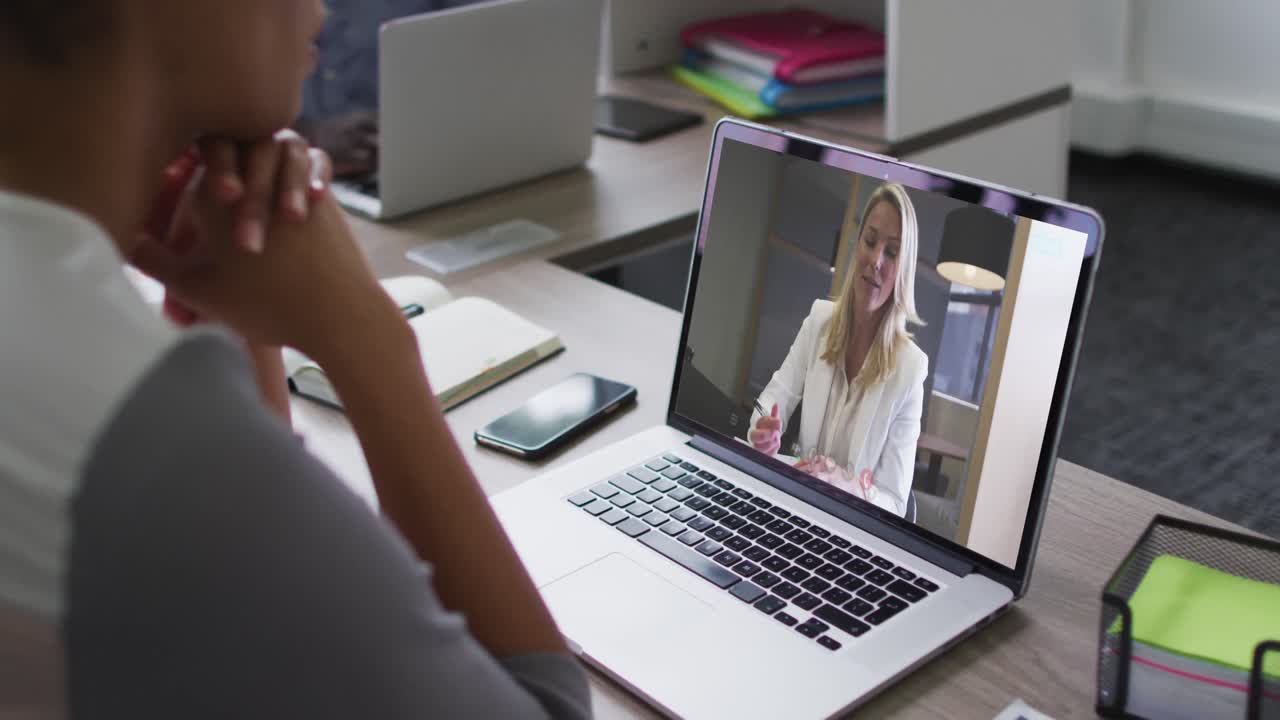 Mid section of african american woman having a video call with female colleague on laptop at office