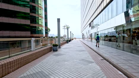 person walks along urban sidewalk near building