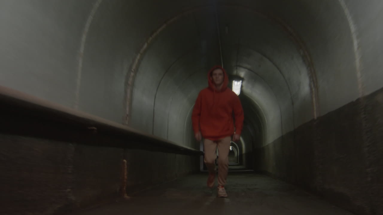 Parkourist Freerunning and Doing Trick in Dark Tunnel