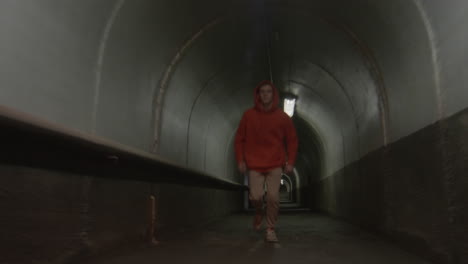 parkourist freerunning and doing trick in dark tunnel