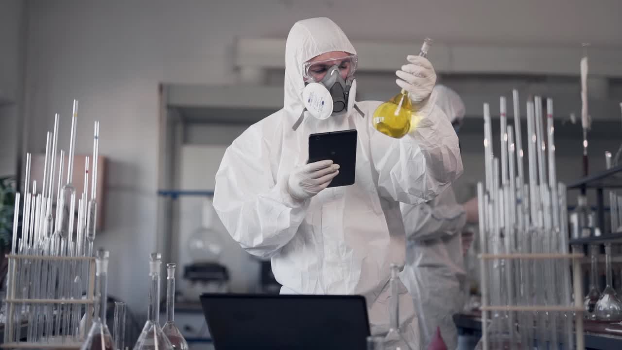 los científicos de laboratorio modernos trabajan en trajes protectores y respiradores